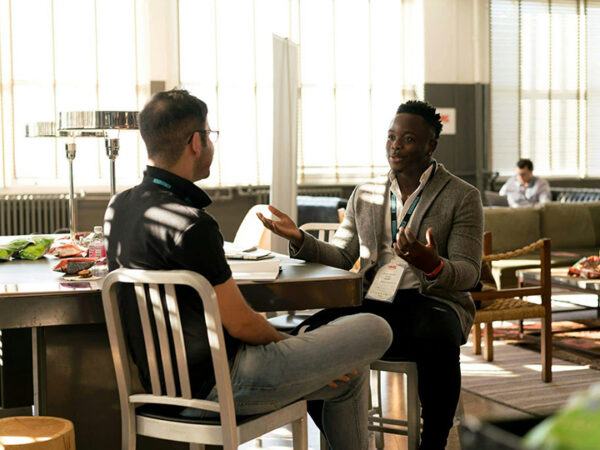 Two men talking at a table in an office for business advice