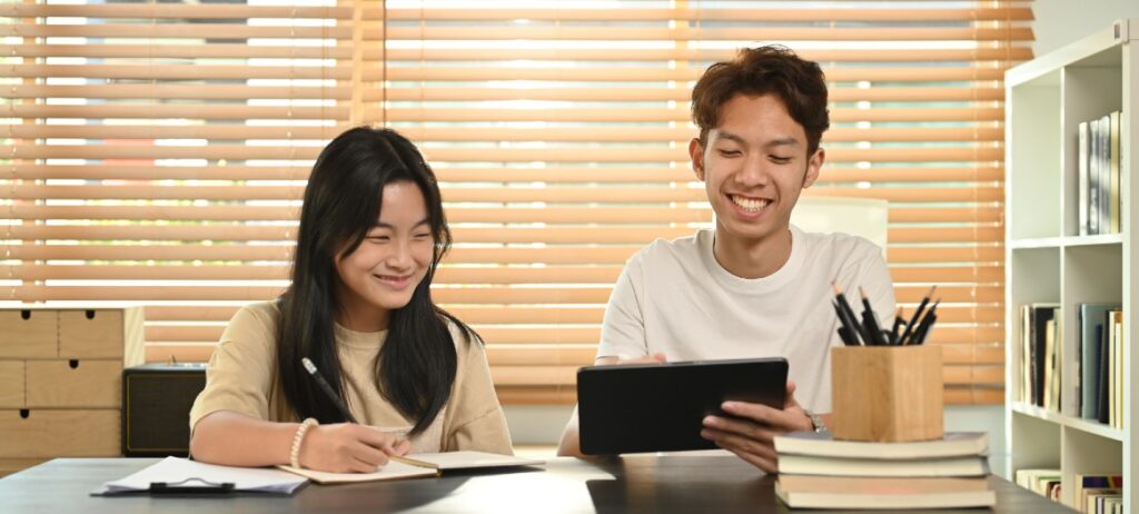 Students studying together with tablet and notebooks.