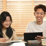 Students studying together with tablet and notebooks.